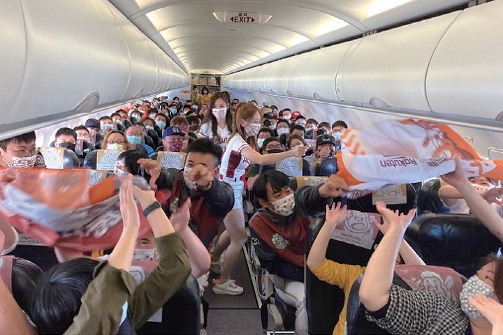 ▲機艙內由Rakuten Monkeys王溢正及黃子鵬帶領球迷們進行傳遞旗幟比賽　圖：台灣虎航╱提供