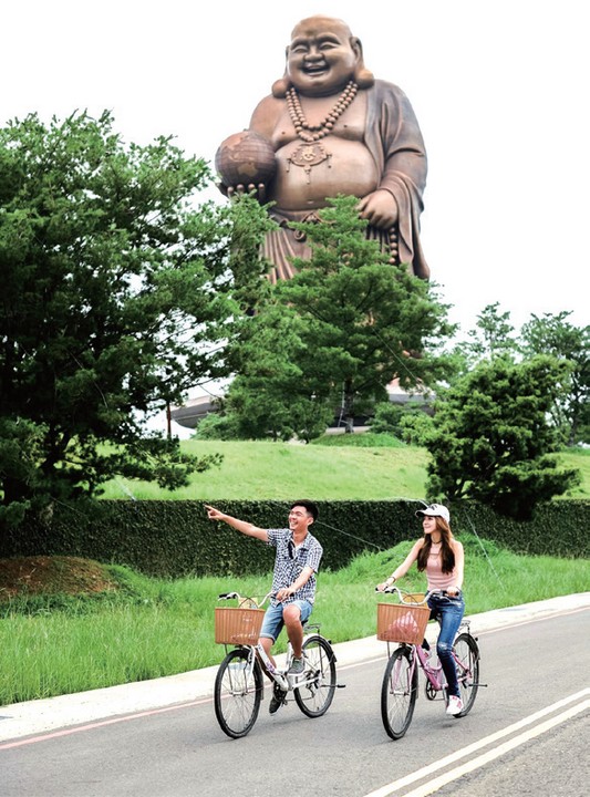 ▲騎乘自行車遊覽天恩彌勒佛像，好不愜意。　圖：新竹縣交通旅遊處╱提供