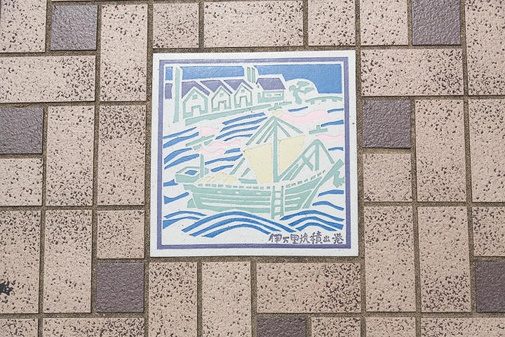 ▲伊萬里市區地上鑲嵌著當時歷史的彩繪磁磚。圖為伊萬里燒出貨搭船出港的模樣。    圖：元氣佐賀/提供
