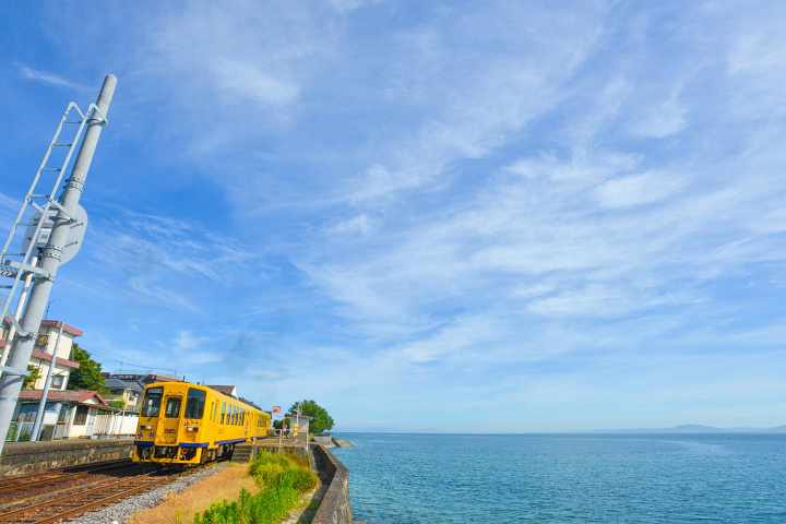 沿著大海行駛的島原鐵道列車，黃色車身格外引人矚目。　圖：島原市／提供