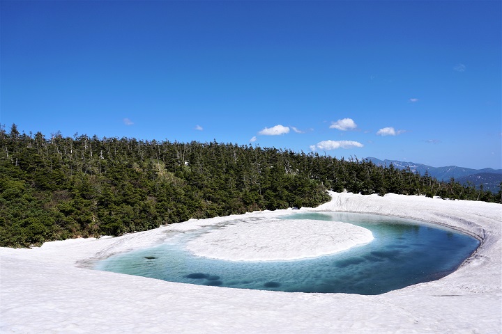 八幡平山頂附近的「龍之眼」（Dragon Eye）是春天融雪後的積水將中央雪地包圍所形成的奇景。　圖：岩手縣／提供