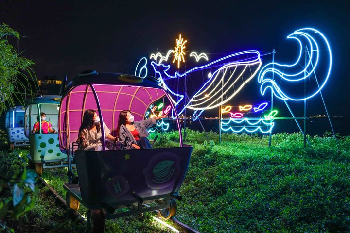 迎著海風騎乘鐵道自行車，各種璀璨燈飾閃耀迷人光輝。　圖：新北市政府觀光旅遊局／提供