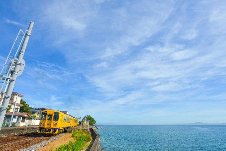 ▲島原鐵道旁就是有明海，黃色車身在藍天白雲陪襯下格外搶眼。　圖：島原市／提供 
