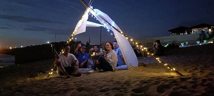 ▲旅客在龍門晚宴後在沙灘上享受夏日晚風輕拂。　圖：龍門海潮餐桌／提供
