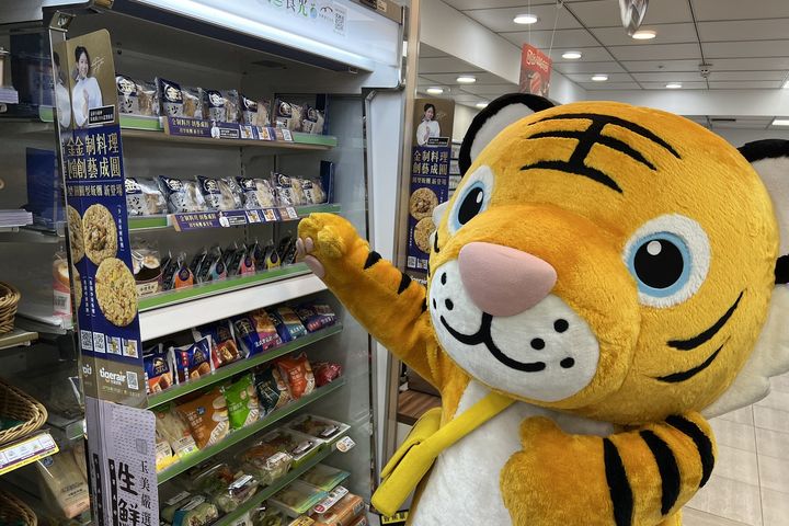 台虎虎將在鮮食冷櫃前選購新上市的全家金飯糰。　圖：台灣虎航／提供 