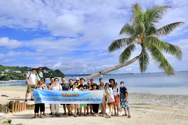 菲律賓觀光部台灣分處處長海瑟博士（中）與台灣旅遊業者們於長灘島布拉波海灘（Bulabog Beach）同著名Leaning Coconut Tree合影。　記者-梁書眉／攝