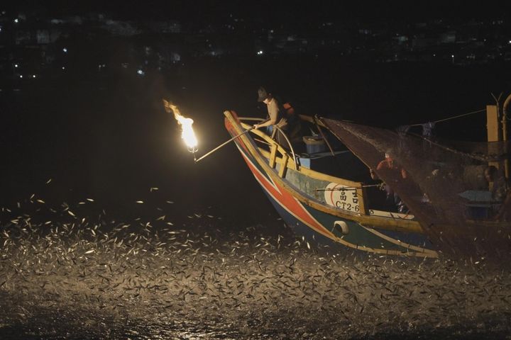 ▲漁船點燃磺火，吸引成千上萬的青鱗魚飛躍海面。　圖：新北市政府觀光旅遊局／提供