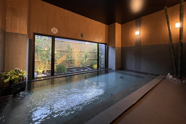 ▲天然溫泉大浴場「旅人之湯」雖在室內，但仍能一邊泡湯一邊欣賞造景。　圖：Route Inn Japan co., Ltd.／來源