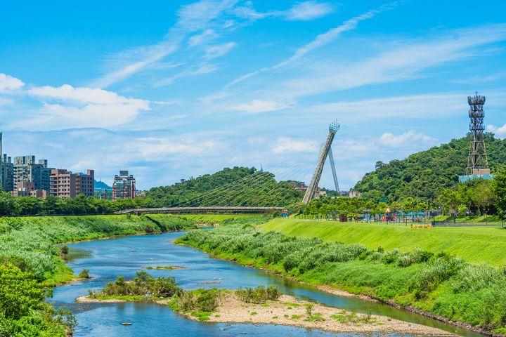 ▲汐止的地標「星光橋」兩側擁有風景秀麗的河濱自行車道，以及綠意盎然的草坡綠野。　圖：新北市政府水利局／提供