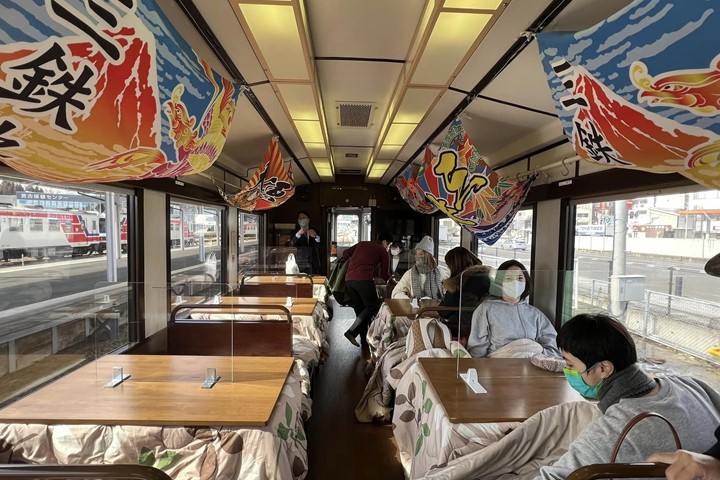 ▲列車內懸掛大漁豐收旗幟與暖爐桌，充滿濃厚的在地風情。　圖：向日遊顧問有限公司／提供