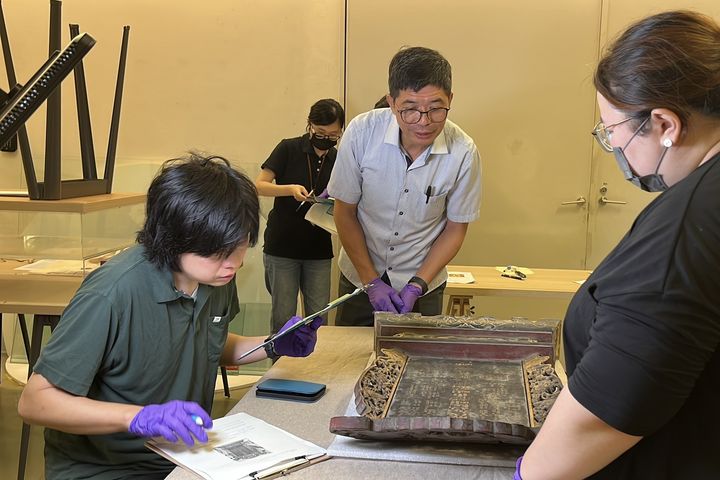 ▲何金樑主任(中)與民博奈良雅史副教授(左)進行客發中心館藏客家家族神牌位點驗。　圖：客家委員會客家文化發展中心／提供