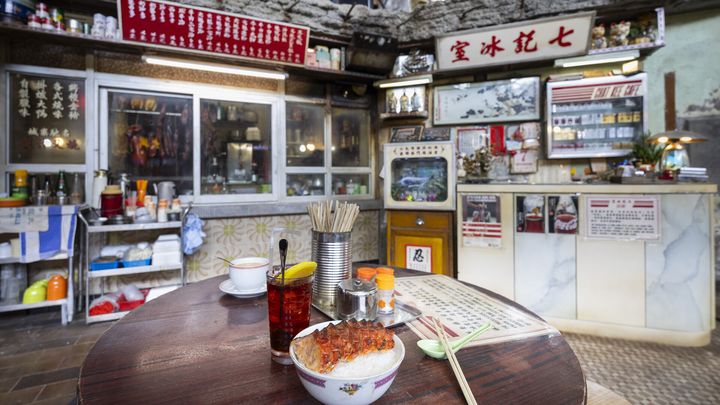 ▲七記冰室為電影中街坊聚頭地方，場景內懸掛仿真燒味，以及飯桌上那碗於電影中見證兄弟情義的叉燒飯。　圖：香港旅遊發展局／提供