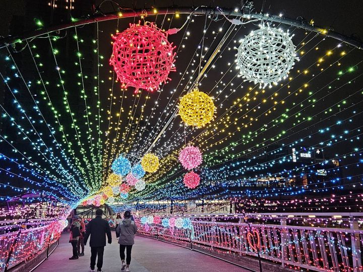 ▲拱型的炫彩光廊中，以七彩星星燈點綴著情人節夜空。　圖：新北市政府水利局／提供