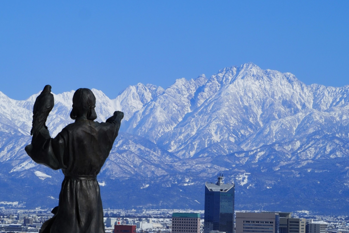 富山市吳羽山公園展望台上「立山開山祖」佐伯有頼指向立山山脈連峰的雕像。　圖：Photo AC／來源
