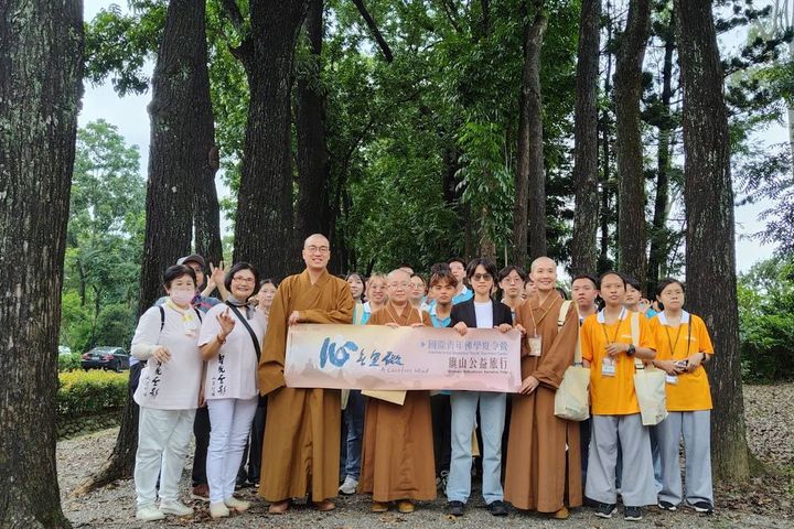 佛光山佛學夏令營一行人與茂管處黃怡寧科長於桃花心木下合影。　圖：茂林國家風景區管理處／提供