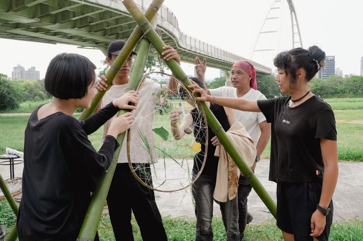  策展人李簣至協助創作營團隊學習如何在戶外設置藝術裝置。　圖：新北市政府水利局／提供