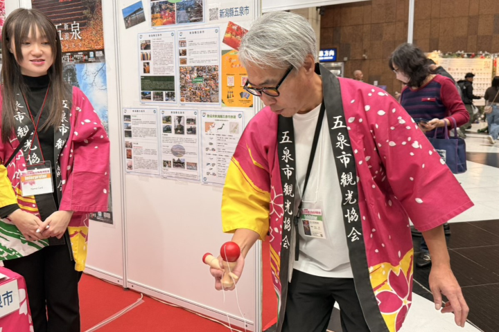 ▲現場只要挑戰劍玉遊戲，就可以獲得限量的當地針織杯墊。　記者-游琮玄／攝