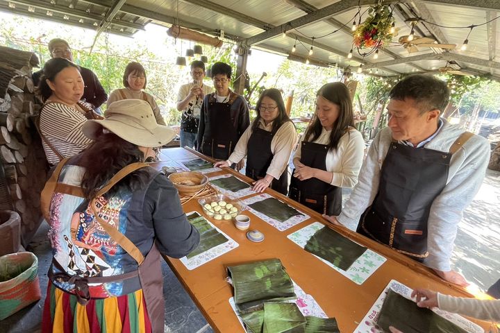 ▲在神山部落「魯凱百步蛇風味餐廳」體驗部落廚藝學校課程，帶領貴賓深入家庭農園採集食材，並親手製作「巴冷公主的下午茶」，完成以香蕉葉包裹小米糰與花生碎的「小米阿拜」。　圖：茂林國家風景區管理處／提供