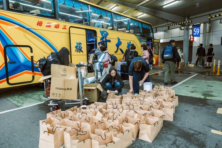 ▲為客人安排接送車，在遊覽車旁準備好一袋一袋的豬腳麵線餐盒，讓客人回程的車上可以用餐。　圖：何時旅遊／提供