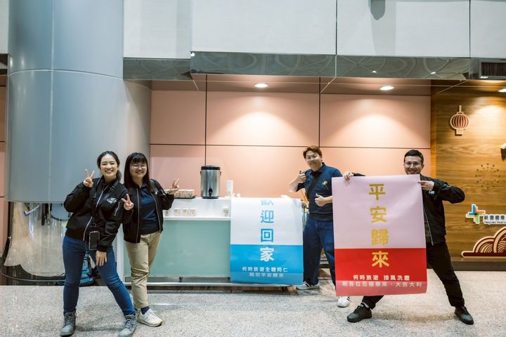 ▲何時旅遊特別印製歡迎回家和平安歸來的海報接機，旁邊是整桶的無咖啡因熱茶。　圖：何時旅遊／提供