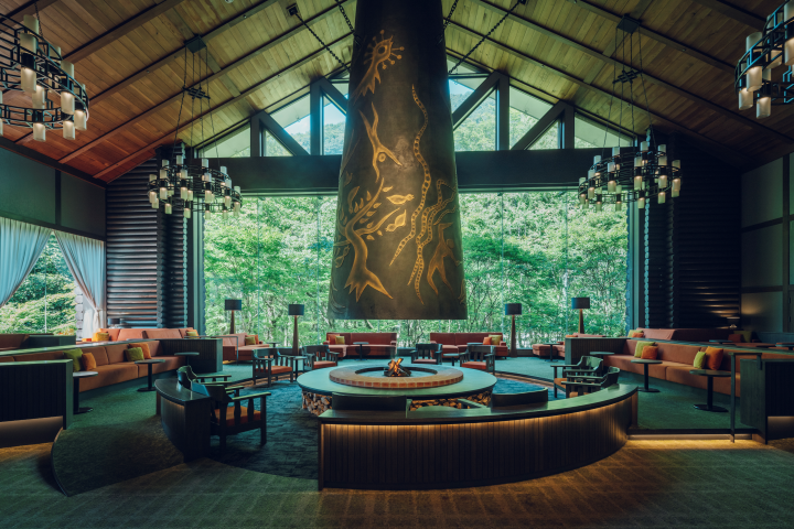  ▲星野集團奧入瀨溪流飯店的大廳空間，設有由藝術家岡本太郎所創作的巨大暖爐，並能透過落地窗欣賞森林景致。　圖：星野集團／提供