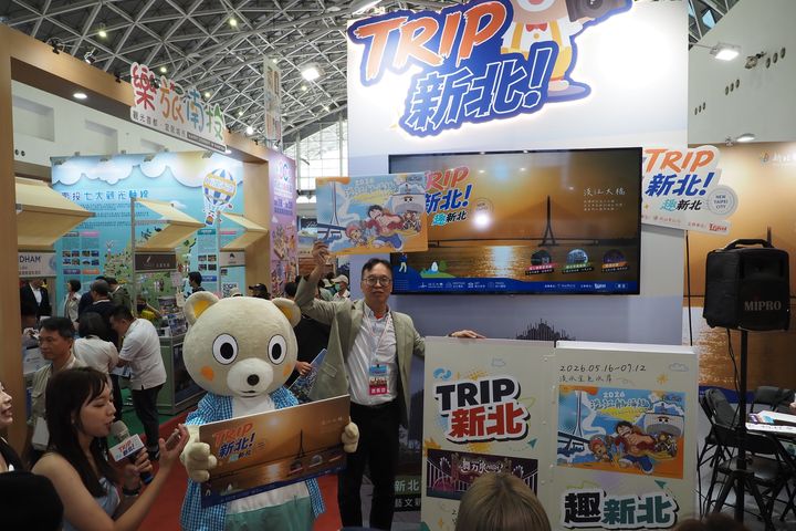 新北市觀光旅遊局長楊宗珉攜手吉祥物新北小客，熱情出席「高雄國際旅展」，為新北館站台造勢並推廣最新旅遊活動。　圖：新北市政府觀光旅遊局／提供 