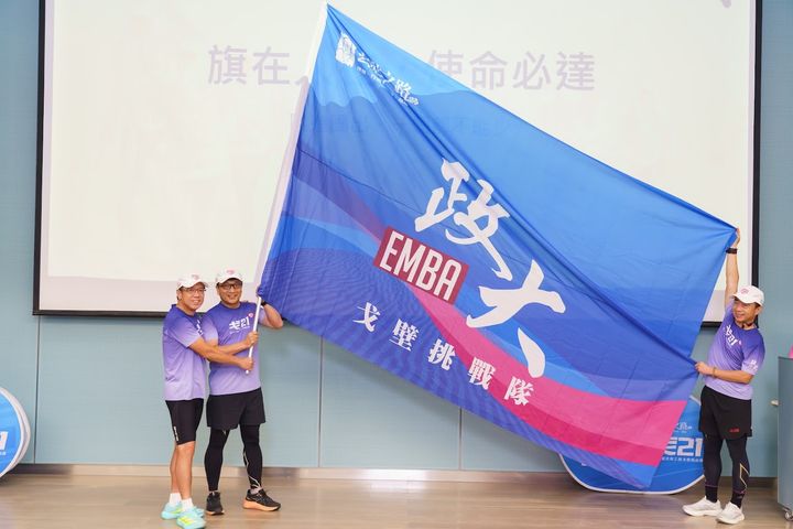▲黃家齊院長親自授旗，由「戈21」會長黃士元代表團隊接下隊旗，象徵「戈21」正式迎接戈壁挑戰。　圖：政大戈21／提供